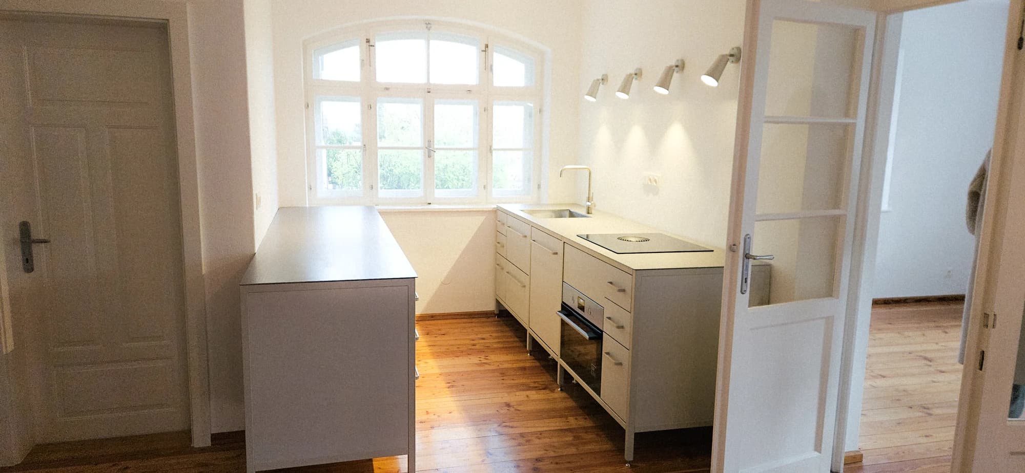 Fertige keep Küche im Altbau: Wandzeile mit Spüle und Kochfeld, gegenüber eine Halbinsel mit Kompaktofen